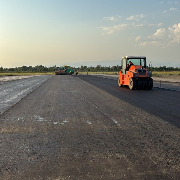 HAMM roller compacting asphalt at sunset
